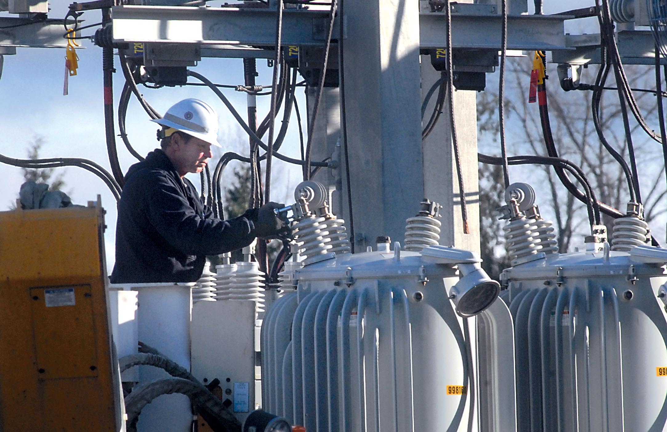 Utility worker Mark Earl of the Clallam County Public Utility District unhooks a damaged power regulator at the Lairds Corner substation west of Port Angeles on Saturday after a copper thief cut grounding cables around the site. — Keith Thorpe/Peninsula Daily News