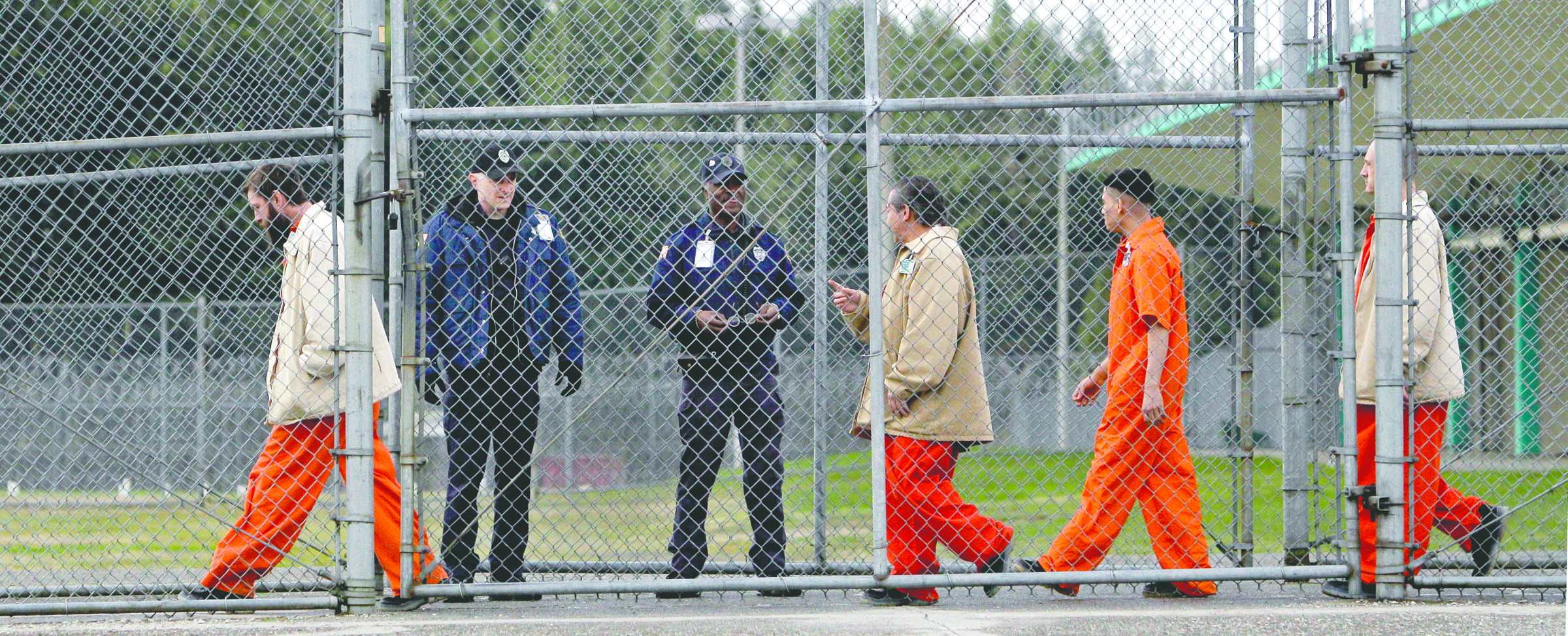 Inmates walk past correctional officers at the Washington Corrections Center in Shelton in February 2011. — The Associated Press