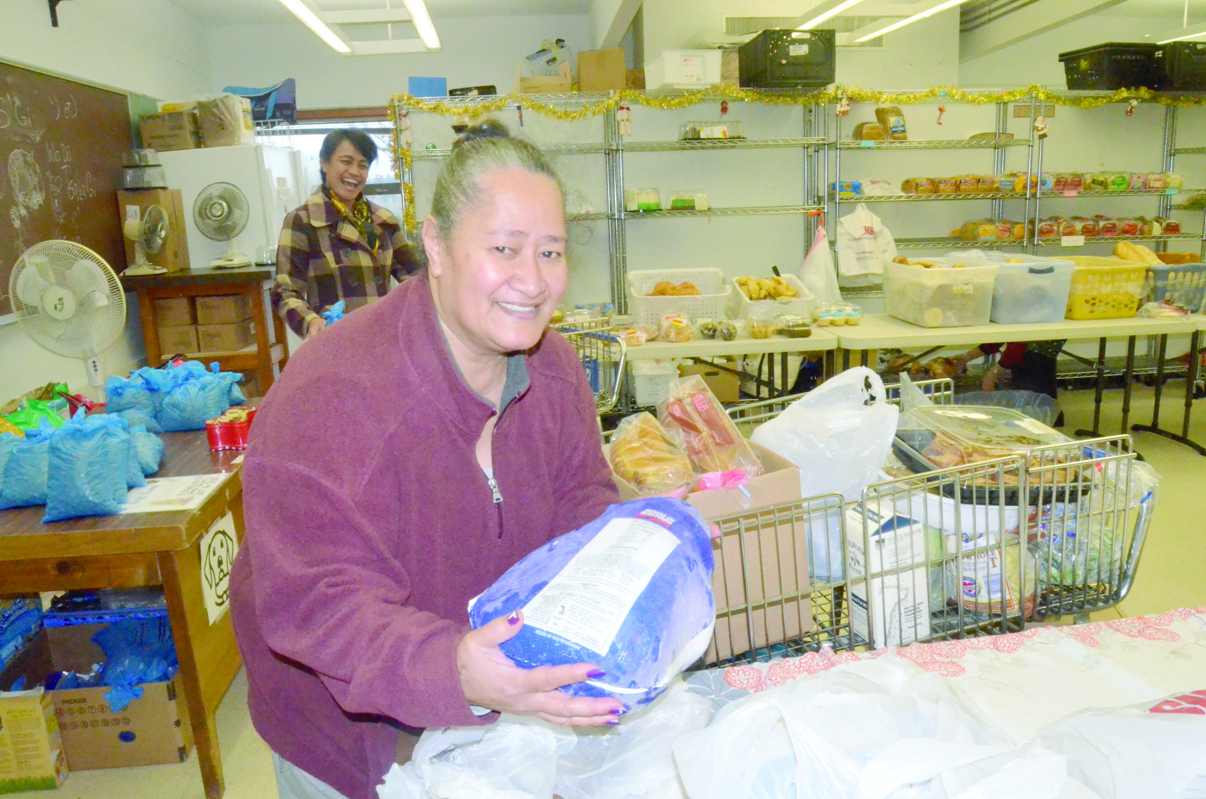 Merita Tavoi of Port Townsend loads a turkey on her cart at the food bank on Monday. —Photo by Charlie Bermant/Peninsula Daily News