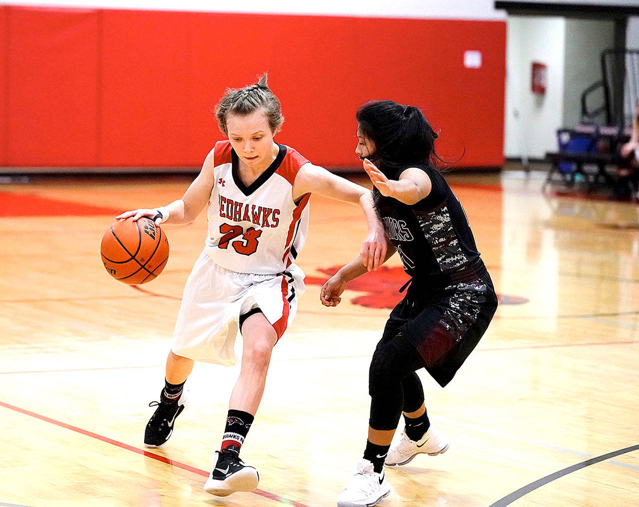 Port Townsend’s Mackenzie Lake pushes her way around Wahluke Warrior Jacky Hidalgo during the opening hame of the 2017 Crush in the Slush tournament at Port Townsend High School on Friday. (Steve Mullensky/for Peninsula Daily News)