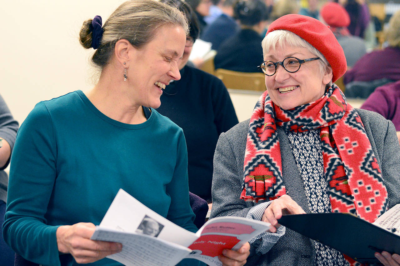 Port Angeles Symphony Chorus members Janis Burger, left, and Bonnie Christianson, seen here last December, are preparing for the symphony’s Holiday Concert at Port Angeles High School on Saturday. (Diane Urbani de la Paz/for Peninsula Daily News)