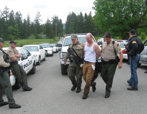 Patrick B. Drum is led off by authorities following his capture following a 3.5-hour manhunt Sunday afternoon. Clallam County Sheriff's Office