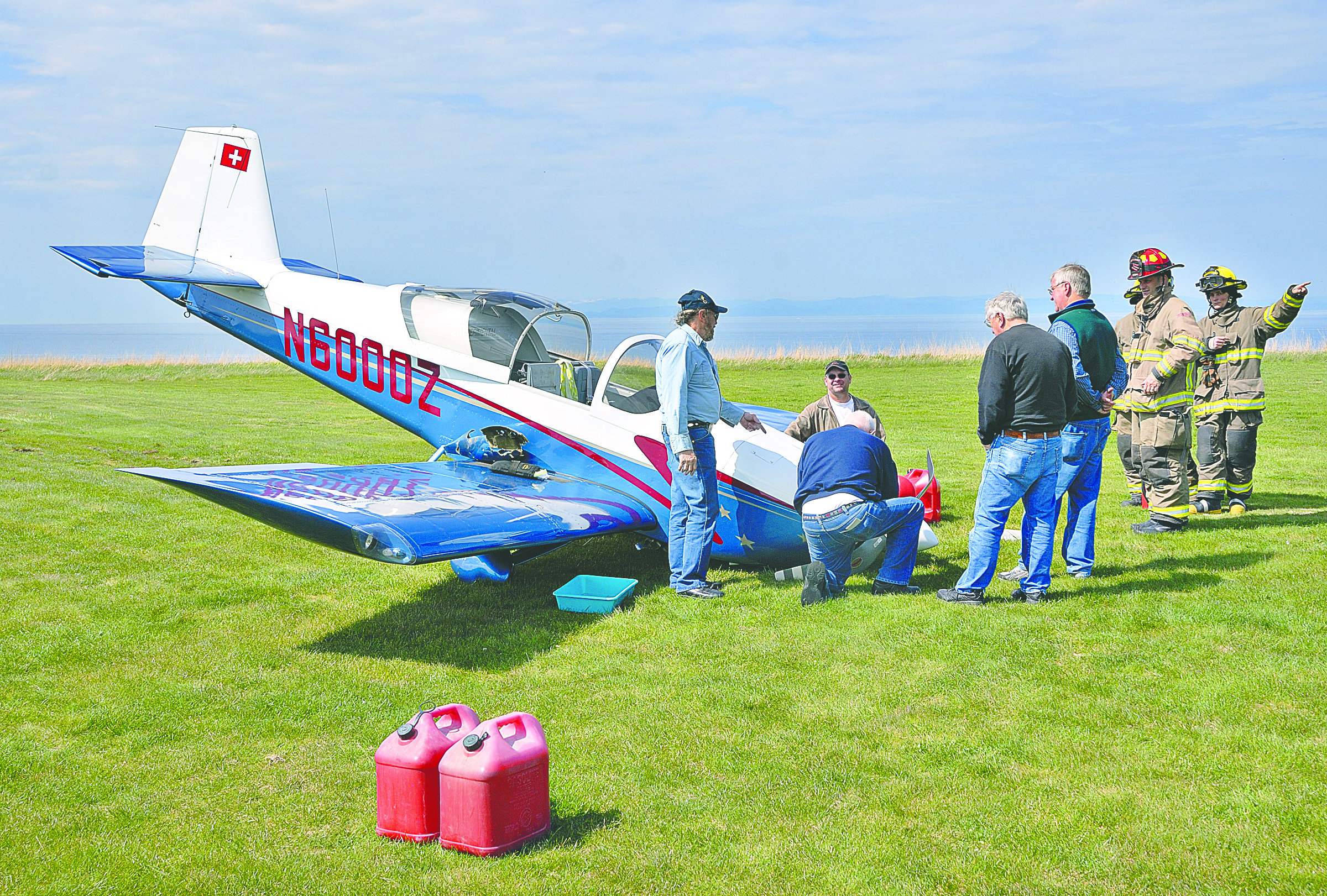 Standing next to a crashed single-engine airplane at the private Blue Ribbon airport near Sequim on Tuesday is