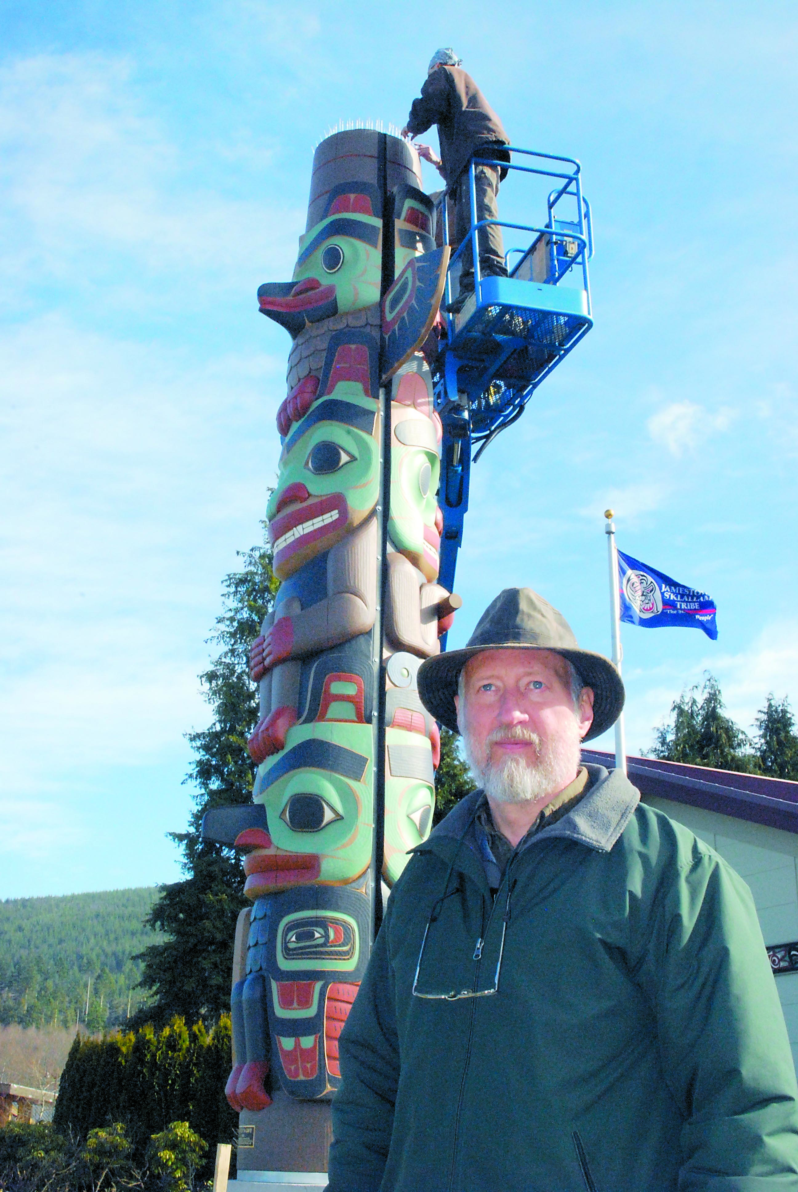 Woodcarver Dale Faulstich at the newly erected two-sided totem pole “Raven's Gift