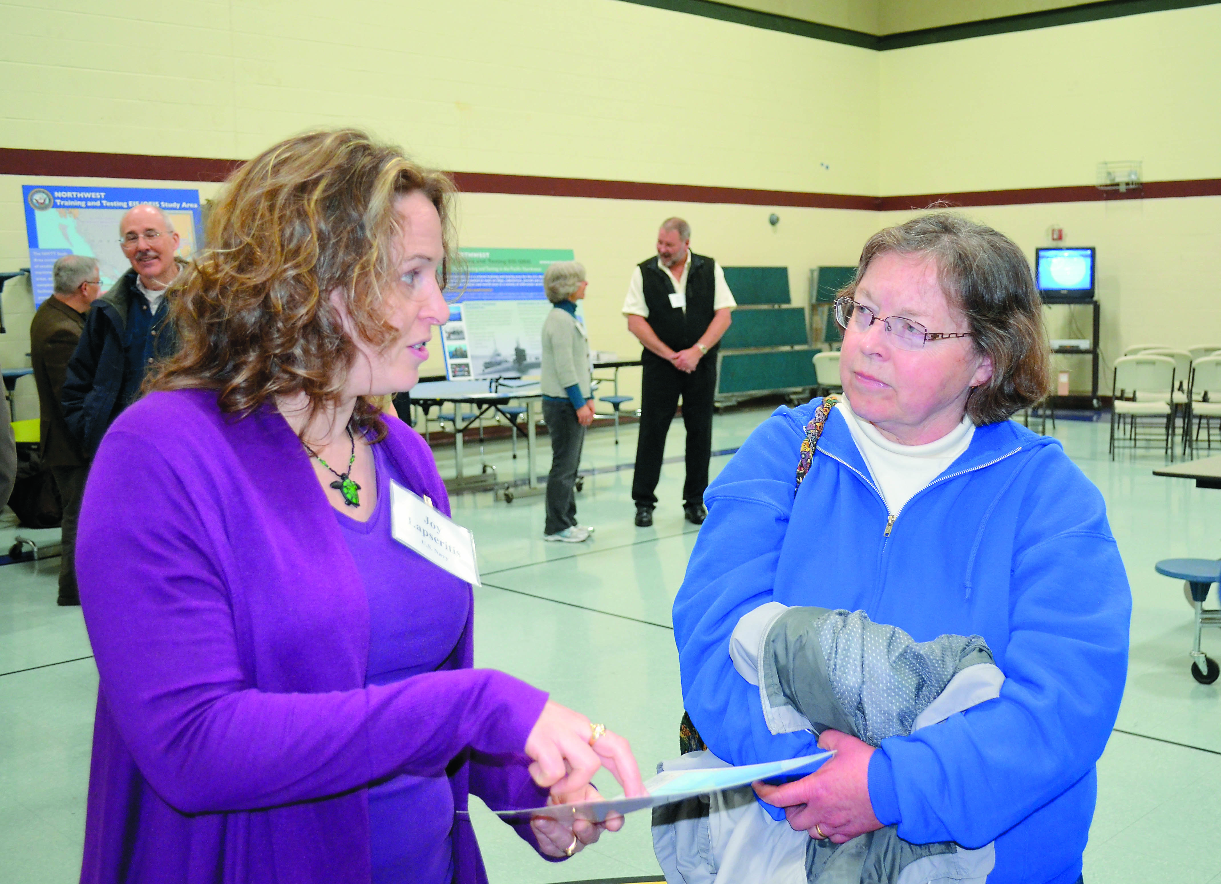 Navy marine biologist Joy Lapseritis explains the reason for updating an environmental impact statement in nautical testing grounds to Quilcene resident Holly Bauman