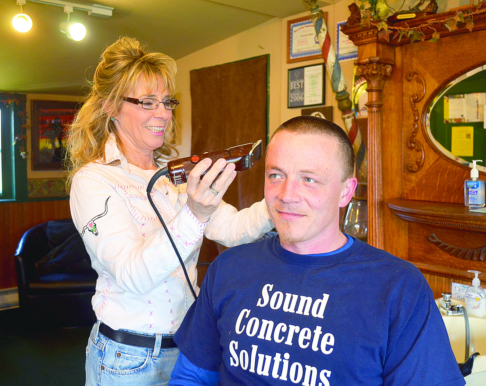 Debi Hinton gives a buzz cut to her son