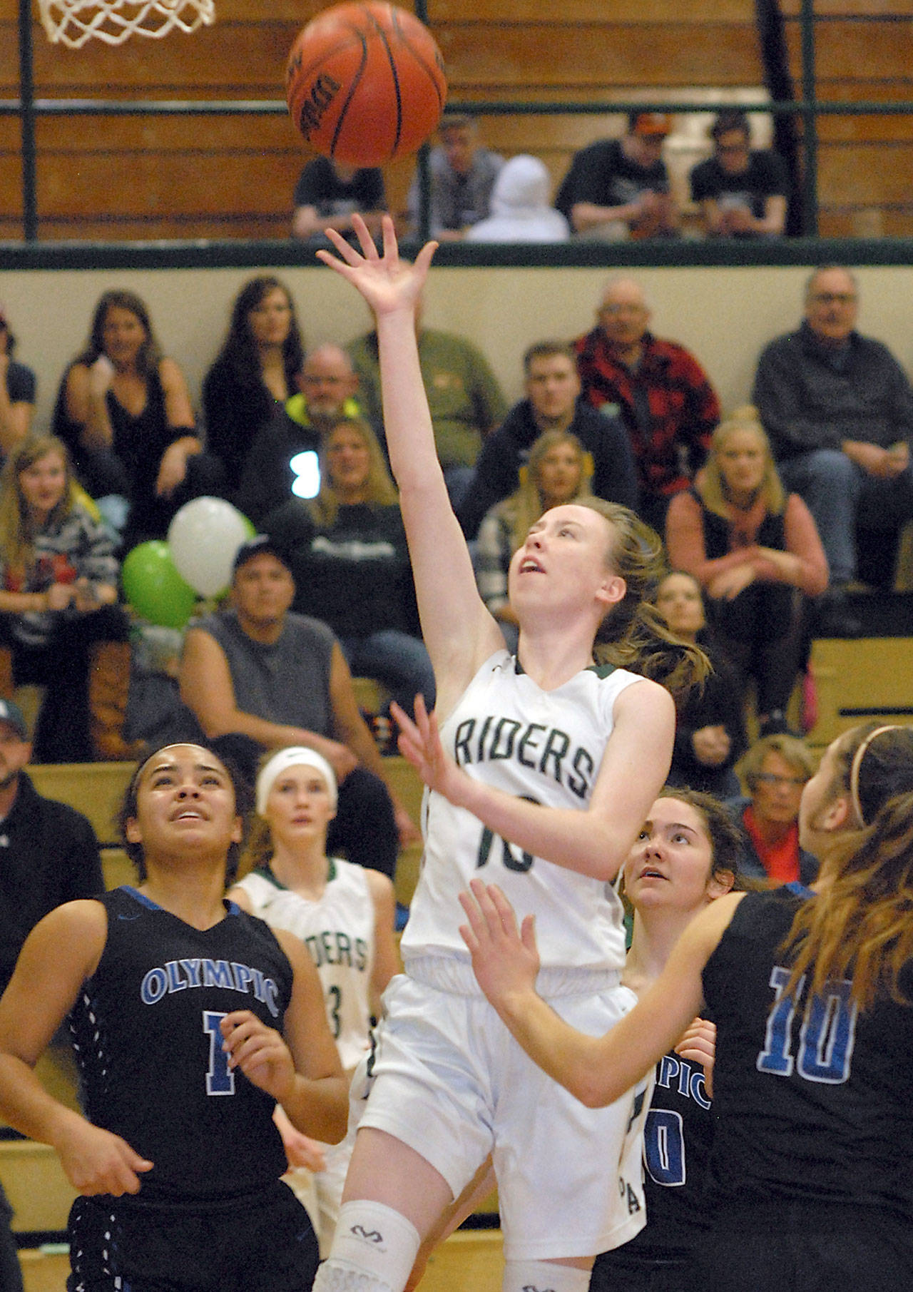 Keith Thorpe/Peninsula Daily News Port Angeles’ Mikkiah Brady goes for the layup surrounded by Olympic defenders, from left, Kiki Mitchell, Zoie Matheny and Dejah Coleman during second-quarter play on Thursday night at Port Angeles High School.