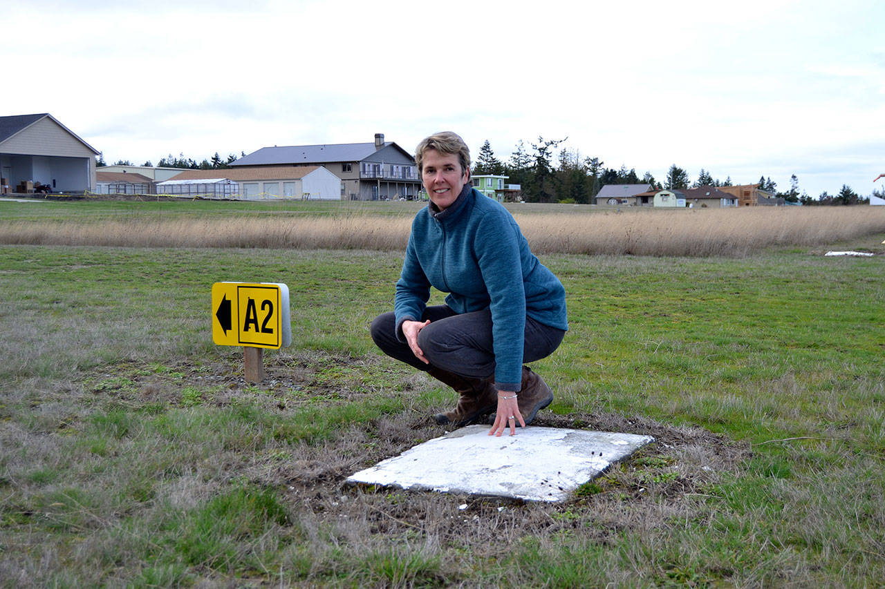 Kaye Gagnon, volunteer for the Diamond Point Airport Association, stands near one of the four corners of the Diamond Point Airport’s helipad. Airport Association members seek up to $8,000 to support paving the helipad to make it safer for airlifts. (Matthew Nash/Olympic Peninsula News Group)