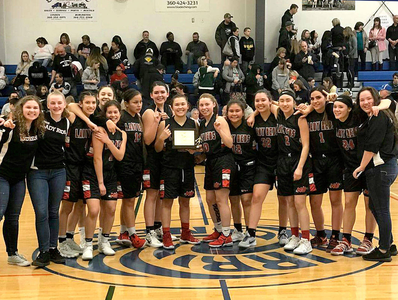 The Tri-District 1B champion Neah Bay girls celebrate their win over Mount Rainier Lutheran on Saturday.