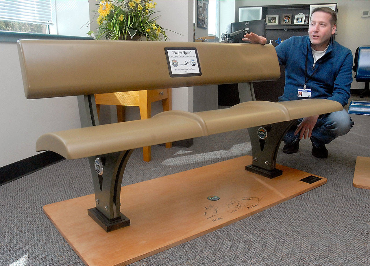 Port Angeles Parks and Recreation Department director Corey Delikat examines a bench made from recycled carbon fiber that will be available for memorials and tributes along the Waterfront Trail. (Keith Thorpe/Peninsula Daily News)