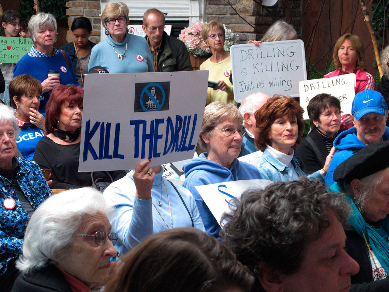 In this Feb. 14, photo, people hold signs protesting President Donald Trump’s plan to allow offshore oil and gas drilling along most of the nation’s coastline at a hearing in Hamilton, N.J. (Wayne Parry/The Associated Press)