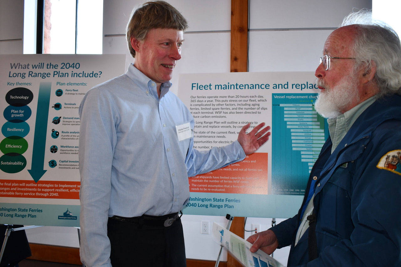 At an open house Thursday, Charles Prestud of Washington State Ferries, left, said 13 of the 23 vessels serving the routes have to be replaced by 2040. Wayne Shaver of Port Townsend said he was surprised that some of the ferries have been in service for 60 years, saying, “That’s a heck of a long time for a boat.” (Jeannie McMacken/Peninsula Daily News)