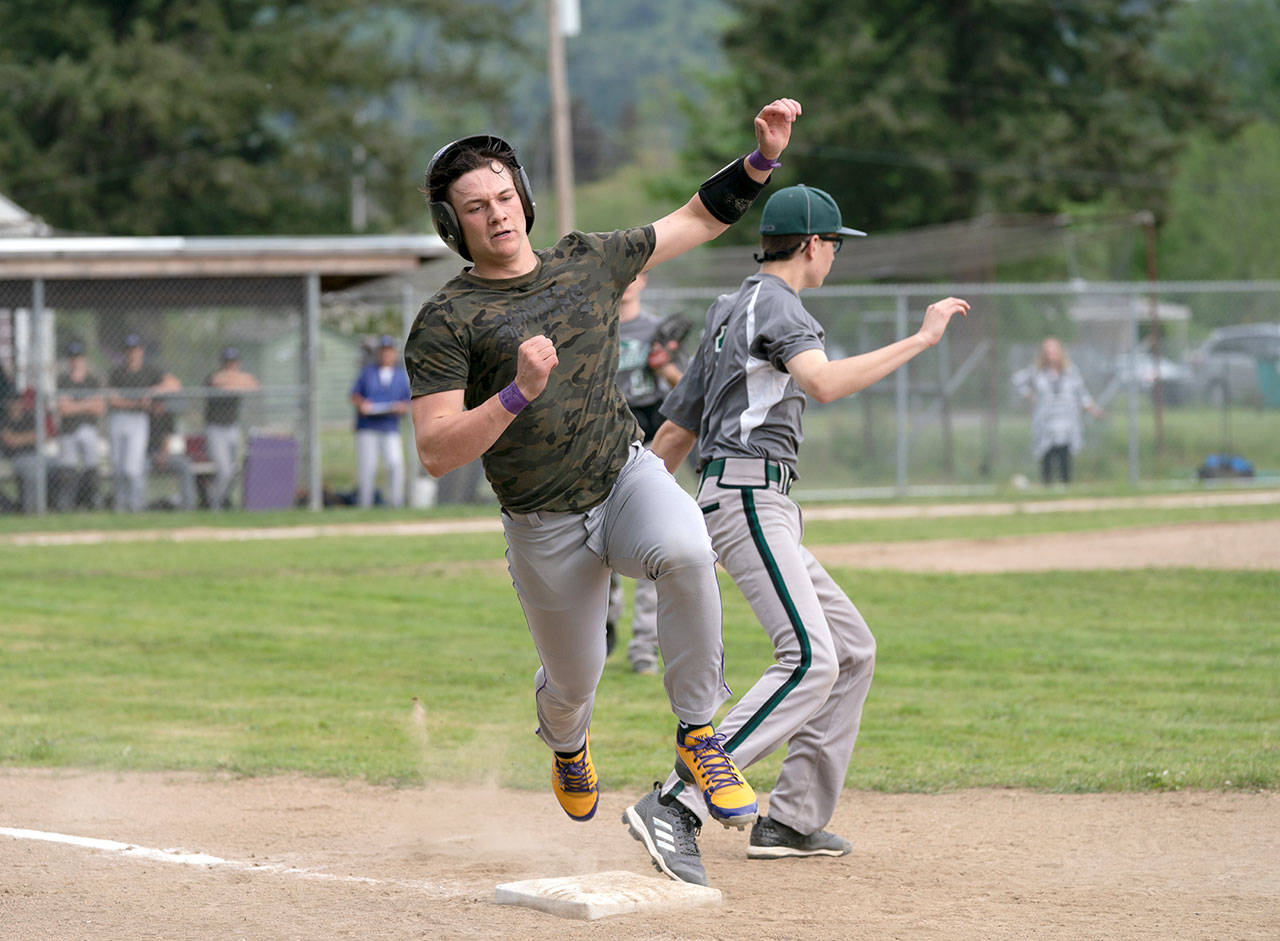 Steve Mullensky/for Peninsula Daily News Quilcene’s Olin Reynolds bounces over first base after hitting a single in a loser-out game against the Mount Rainier Lutheran Hawks on Tuesday in Quilcene.