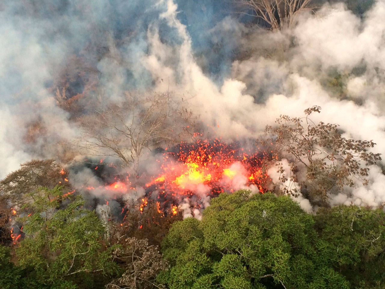 This image provided by the U.S. Geological Survey shows lava spattering from an area on the lower east rift of the Kilauea volcano, near Pahoa, Hawaii. (The Associated Press)