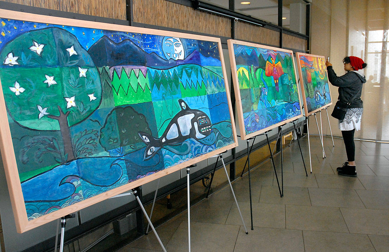 Louise Hagan, a student at Port Angeles High School, takes a cellphone photo of her artistic contribution to a series of mural panels that will adorn walls at Olympic Medical Center in Port Angeles. (Keith Thorpe/Peninsula Daily News)