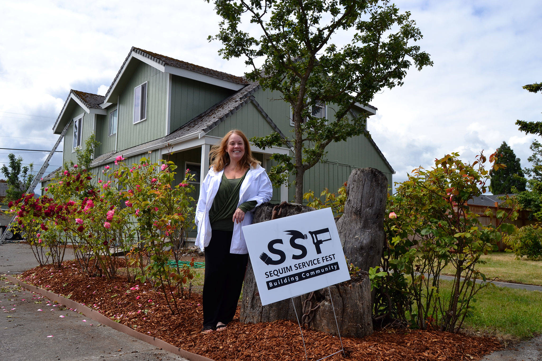 Laraine Claire stands outside her home on the corner of Spruce Street and Fourth Avenue where volunteers helped paint and revitalize her home. She said the project helped inspire hope in her. (Matthew Nash/Olympic Peninsula News Group)