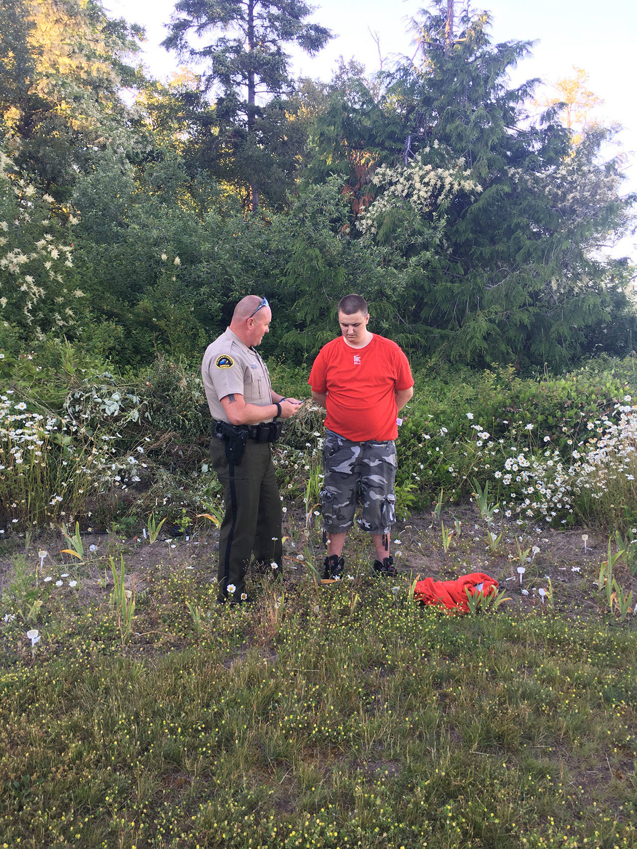 Clallam County Sheriff’s Deputy Don Kitchen is seen with Cayde David Barclay-Paxton on Saturday. (Clallam County Sheriff’s Office)