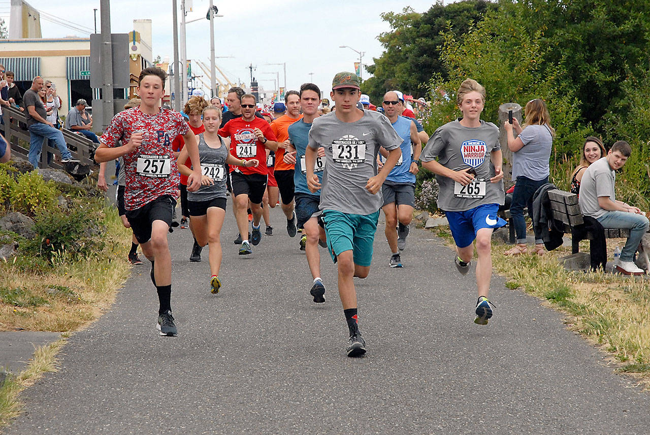 Keith Thorpe/Peninsula Daily News Participants in Friday’s FireCracker 5k/10k dash from the starting line on the Waterfront Trail near Port Angeles City Pier. About 70 people were registered to take part in the run.