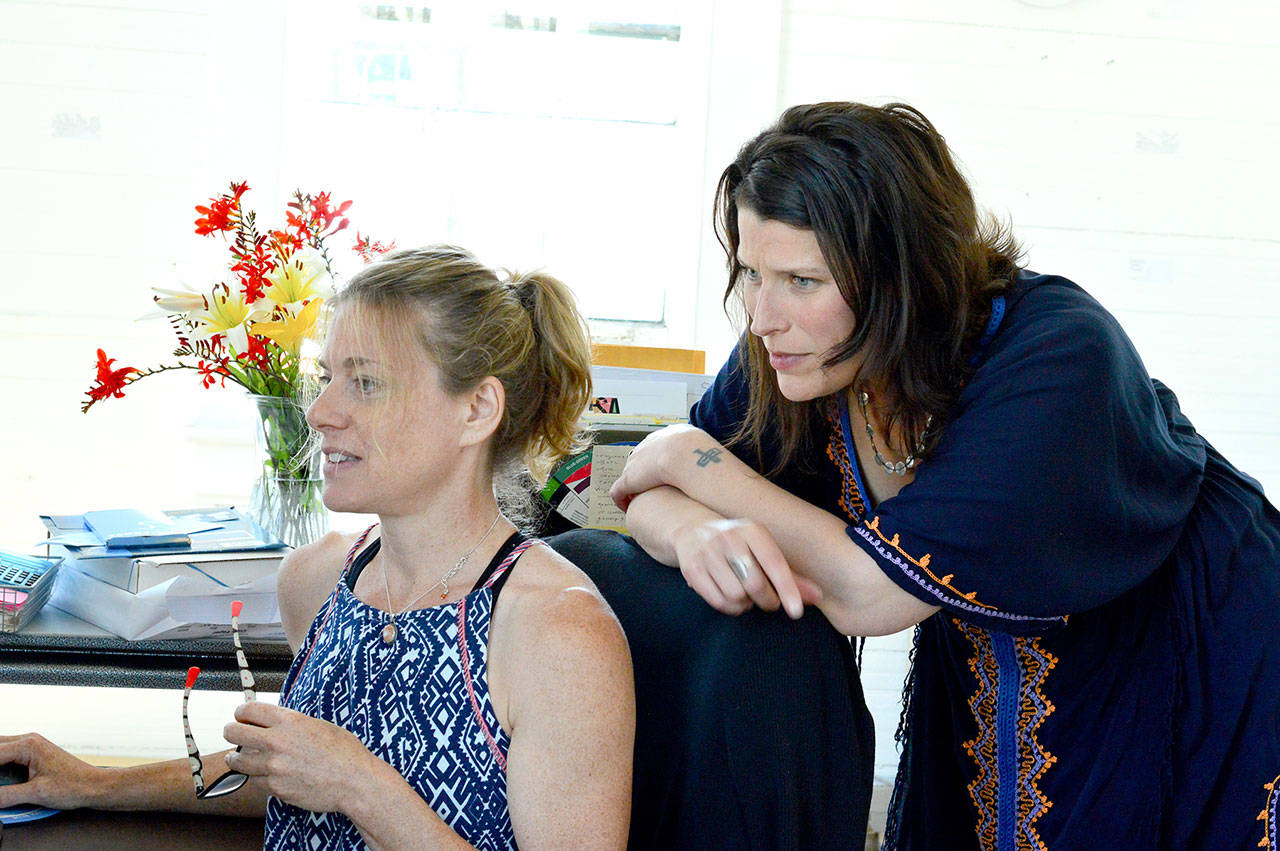 Staffers Julie Christine, seated, and Teresa Verraes coordinate classes and programs such as The Bunker at Fort Worden’s Port Townsend School of the Arts. (Diane Urbani de la Paz/Peninsula Daily News)