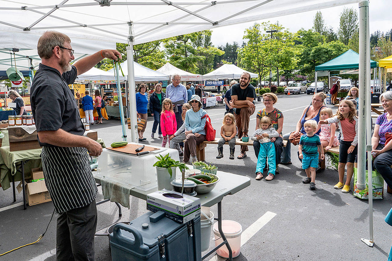 Steve Mullensky/for Peninsula Daily News Arron Stark, executive chef for Jefferson Healthcare in Port Townsend, holds up the peel from a cucumber while giving pointers for cooking healthy foods to kids and adults at the Jefferson County Farmer’s market on Wednesday. Stark demonstrated the making of a healthy dip for a crudite using fresh peas and cottage cheese as part of World Wide Breast Feeding Week with the emphasis on breast milk as the very first healthy food kids get in life. The program was sponsored by Jefferson Healthcare and Jefferson County Public Health. The demos will repeat on Saturday at the Uptown Farmer’s Market.