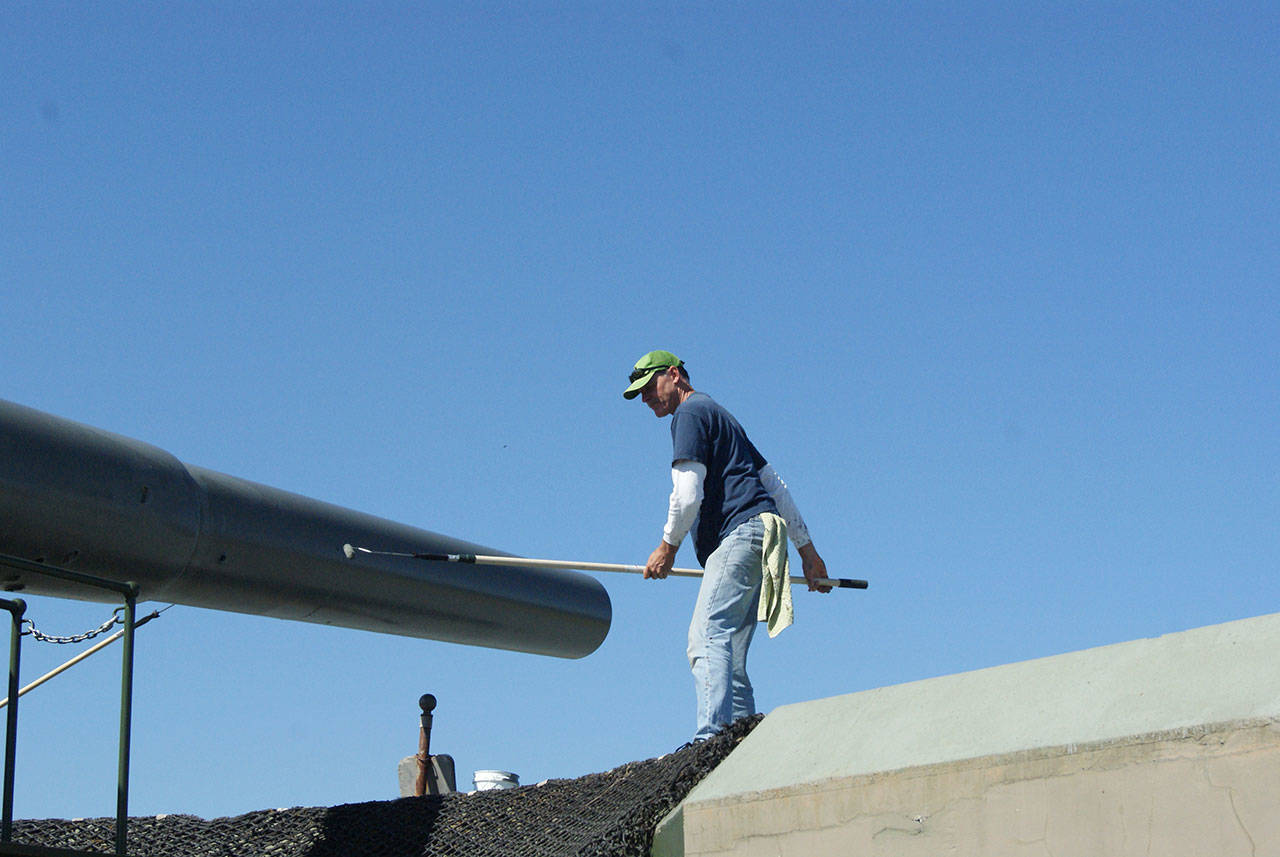 John White of Freeland works to paint the “Big Guns” at Fort Casey. It was a good day to paint, with the sunshine and fresh air, he said. (Maria Matson/Whidbey News Group)