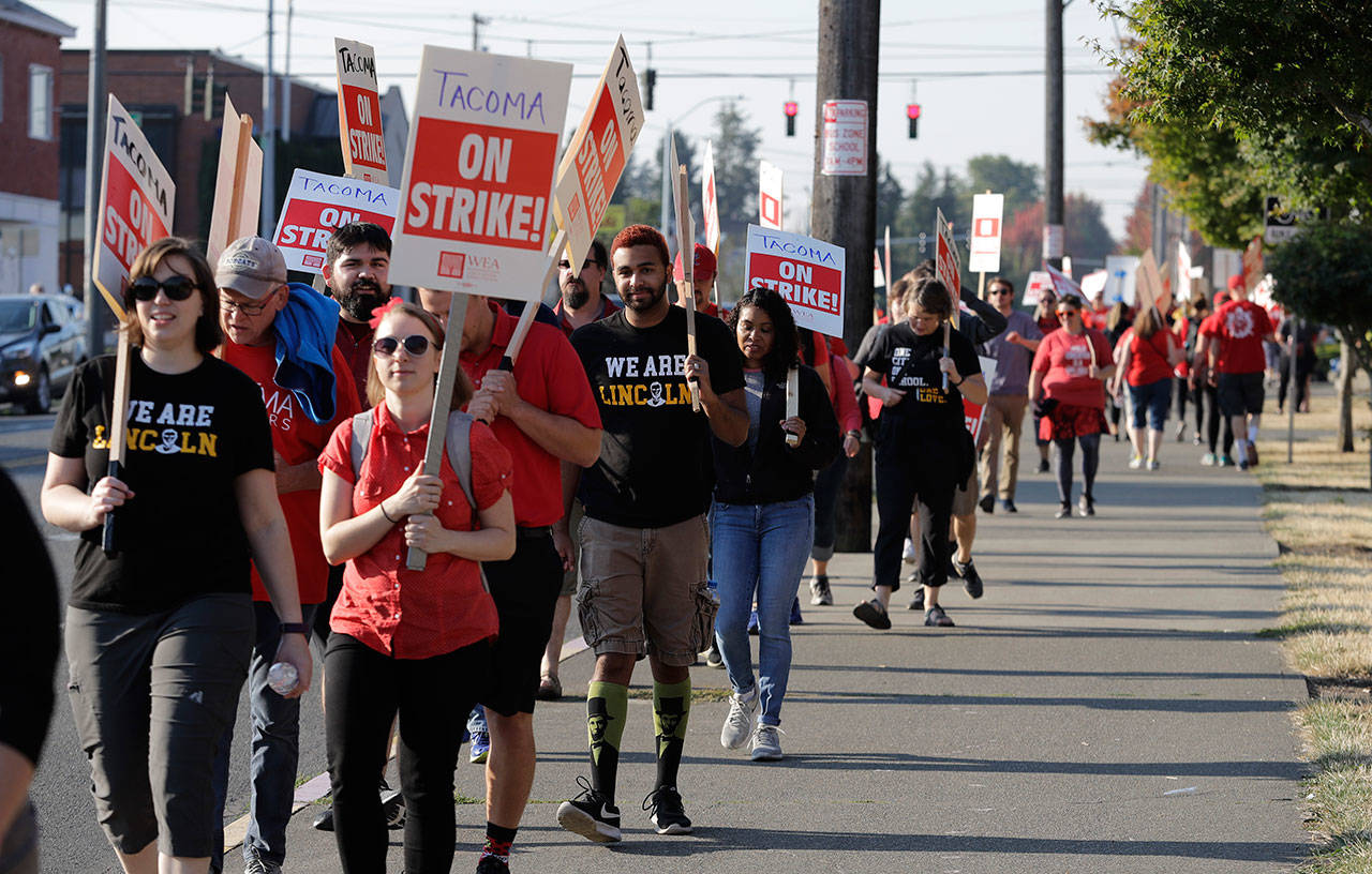 Striking Tacoma Teachers walk a picket line Thursday in front of Lincoln High School in Tacoma. (Ted S. Warren/The Associated Press)