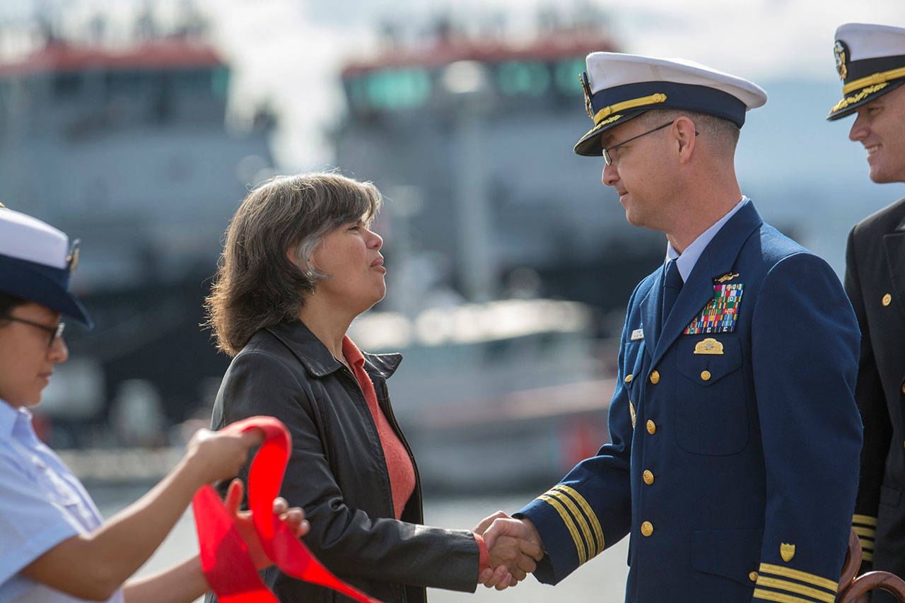 Port Angeles Mayor Sissi Bruch and Cmdr. Thomas Evans, commanding officer of Coast Guard Maritime Force Protection Unit Bangor, shake hands after the ribbon-cutting ceremony for the new Navy pier at Coast Guard Air Station/Sector Field Office Port Angeles on Friday. (Jesse Major/Peninsula Daily News)