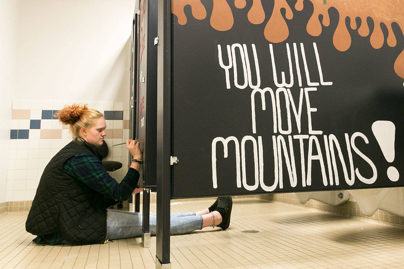 Madison Smith paints a stall in the girls room Tuesday afternoon at Crossroads High School in Granite Falls on September 11, 2018. (Kevin Clark / The Herald)