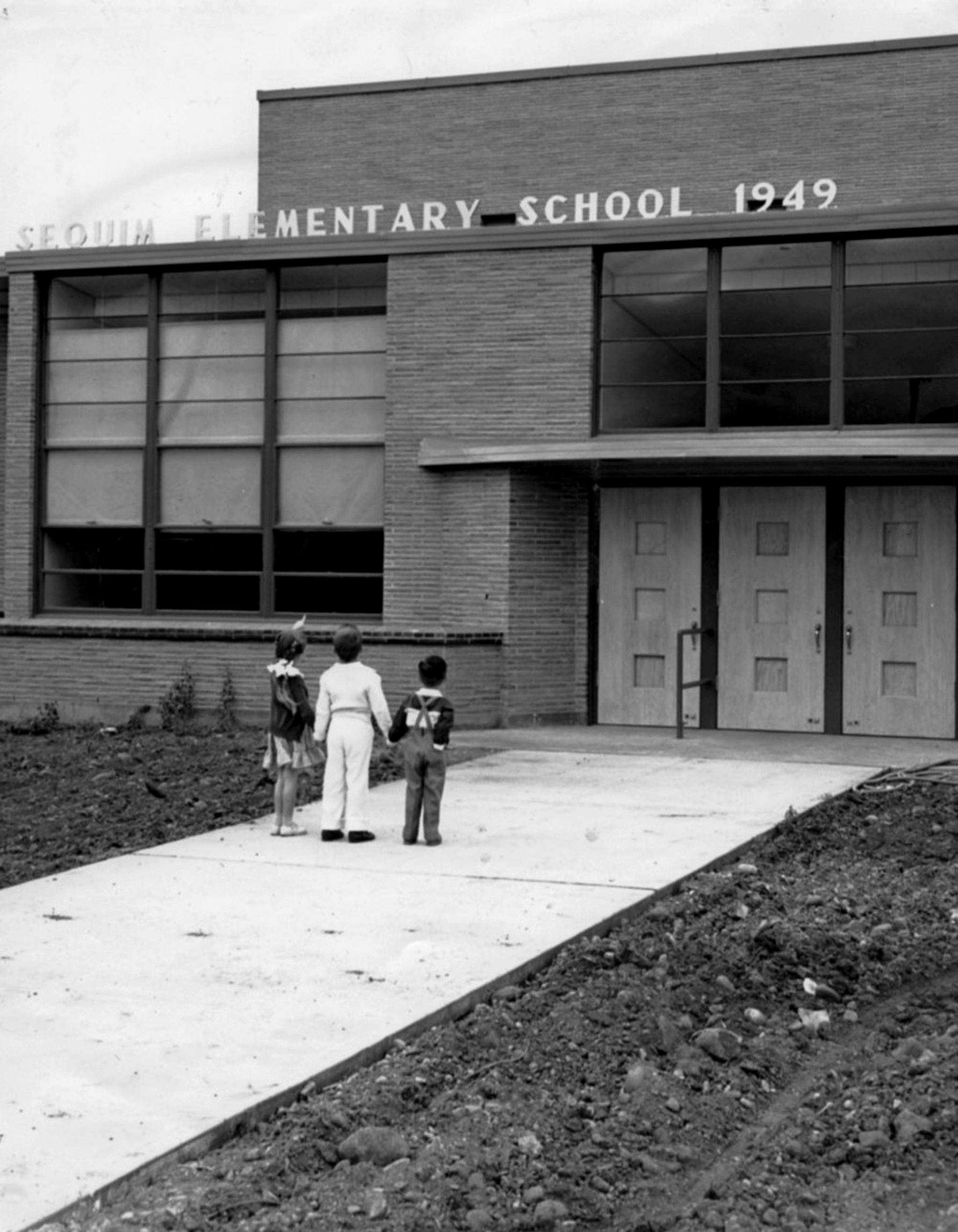 Students look at the new Sequim Elementary School that opened in September of 1949. The school most recently was known as the Sequim Community School that was closed in 2012 and is set to be demolished by the end of the year.