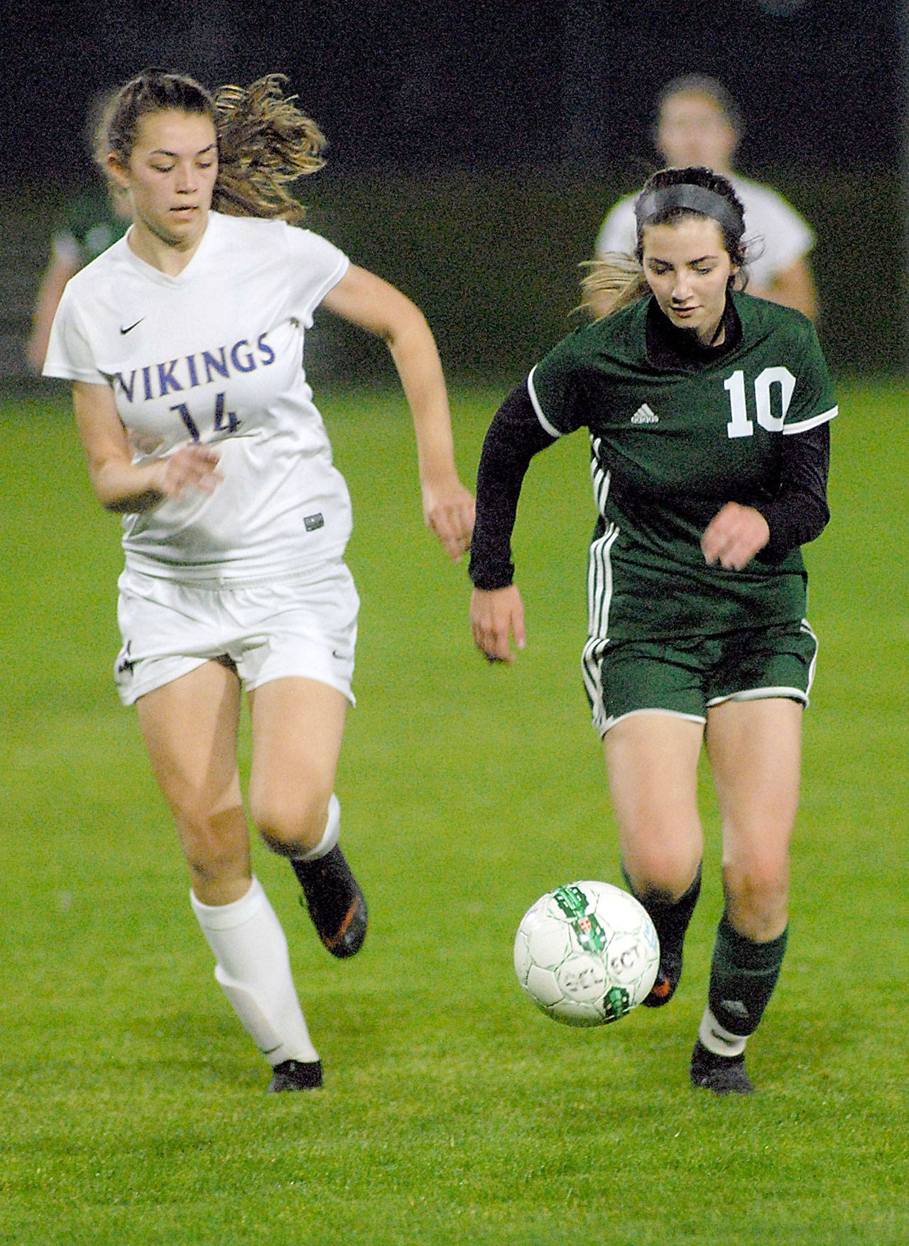 Keith Thorpe/Peninsula Daily News Port Angeles’ Brooklyn Alton, right, outraces Nort Kitsap’s Ashley Castro in their Tuesday night match at Port Angeles Civic Field.