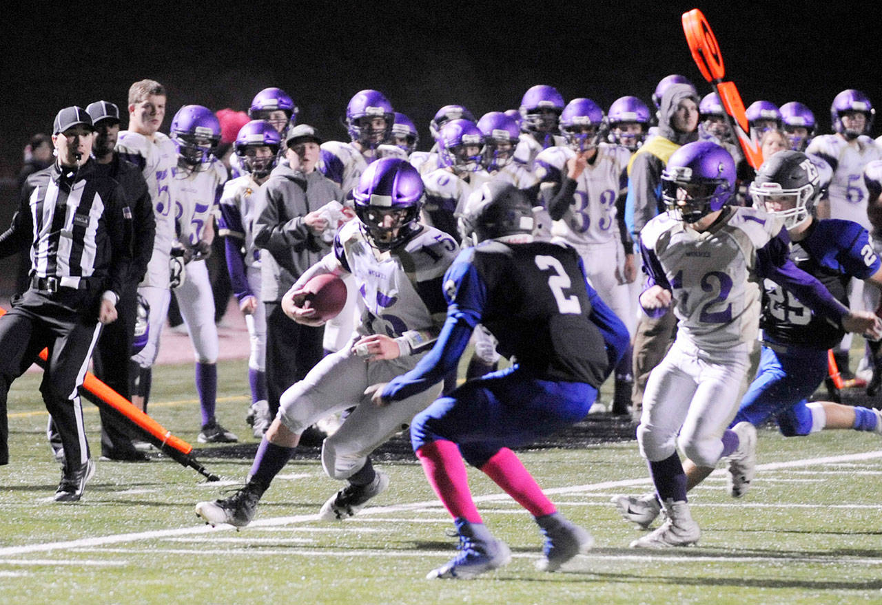 Michael Dashiell/Olympic Peninsula News Group Sequim’s Taig Wiker, left, prepares to make contact with Olympic’s Darrelle White during the Wolves 28-9 win over the Trojans earlier this season.