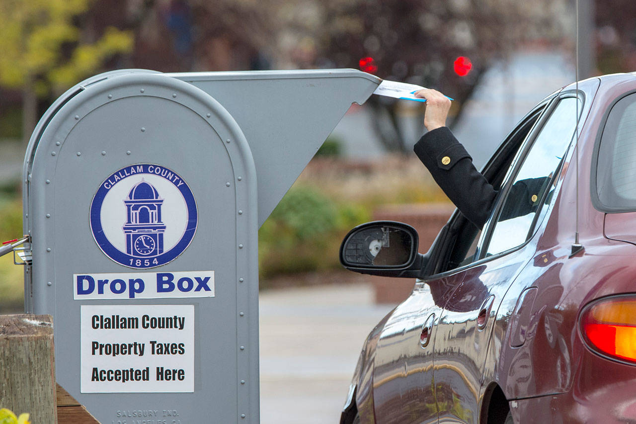 A Clallam County voter drops off a ballot at the Clallam County Courthouse on Monday, a day ahead of Election Day. (Jesse Major/Peninsula Daily News)