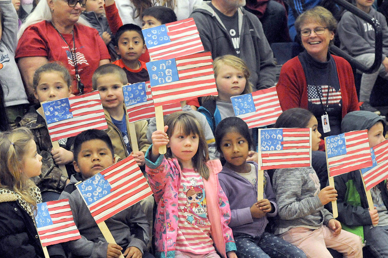 Forks kindergarten students display the colors during the Quillayute Valley School District’s Veterans Day Assembly on Friday afternoon in the Spartan gym. Their teacher, seen to the right, is Karen Wittenborn. Several student speakers, songs, the Quileute Tribe drummers, award presentations, the U.S. Coast Guard color guard school bands honored the many veterans who gathered for the assembly. (Lonnie Archibald/for Peninsula Daily News)