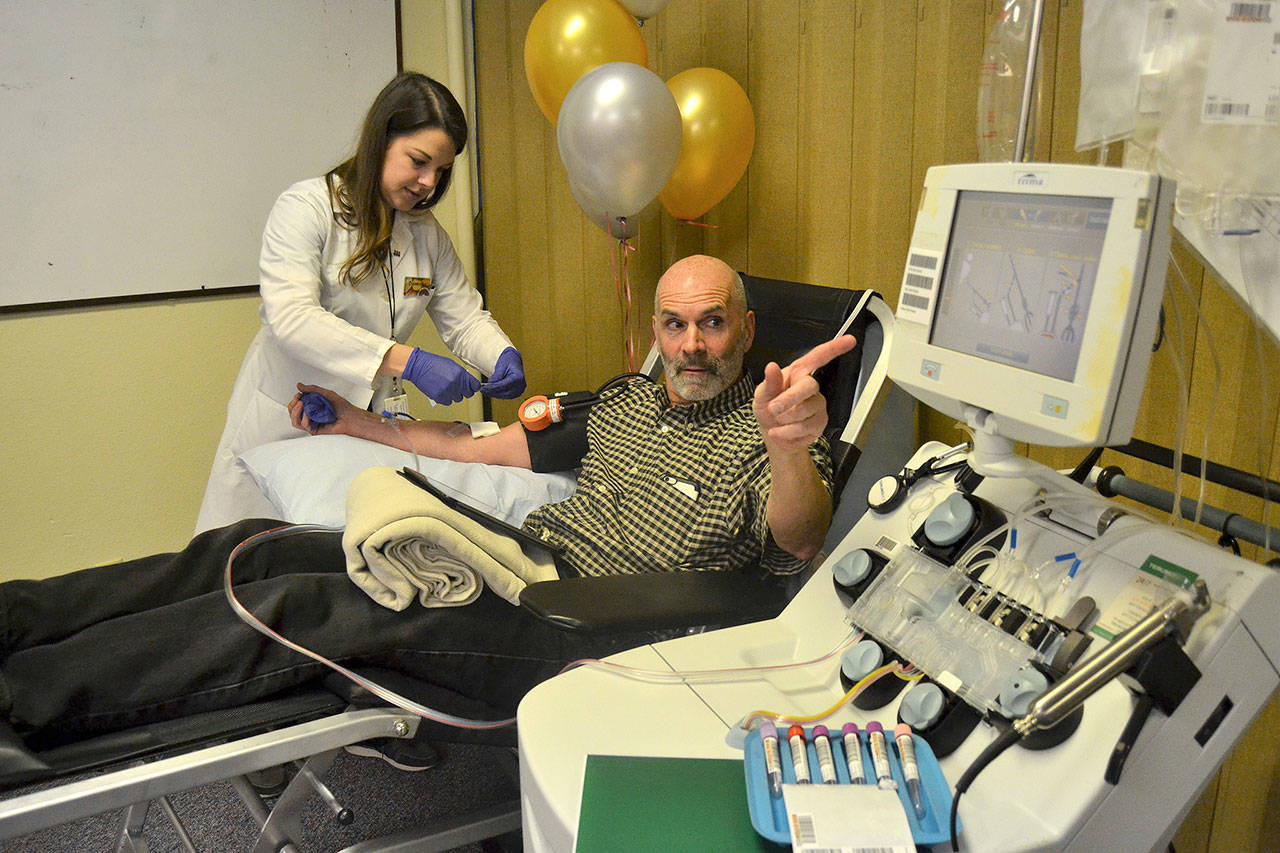 Doug Brundage follows the line as platelets are transferred for a donation for Bloodworks Northwest as Dominika Ujlaky, phlebotomist, readies for him the rest of the donation. (Matthew Nash/Olympic Peninsula News Group)