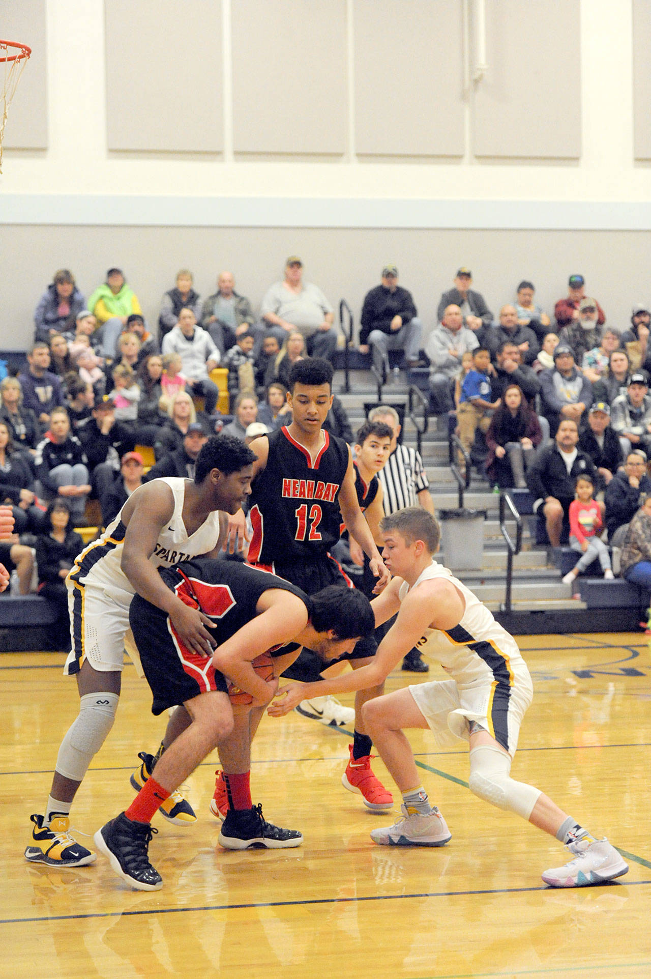 Lonnie Archibald/for Peninsula Daily News                                Forks’ Trey Baysinger (left) and Joseph Reaume trap Neah Bay’s Cameron Moore during the Spartans’ 67-64 win over Neah Bay on Wednesday.