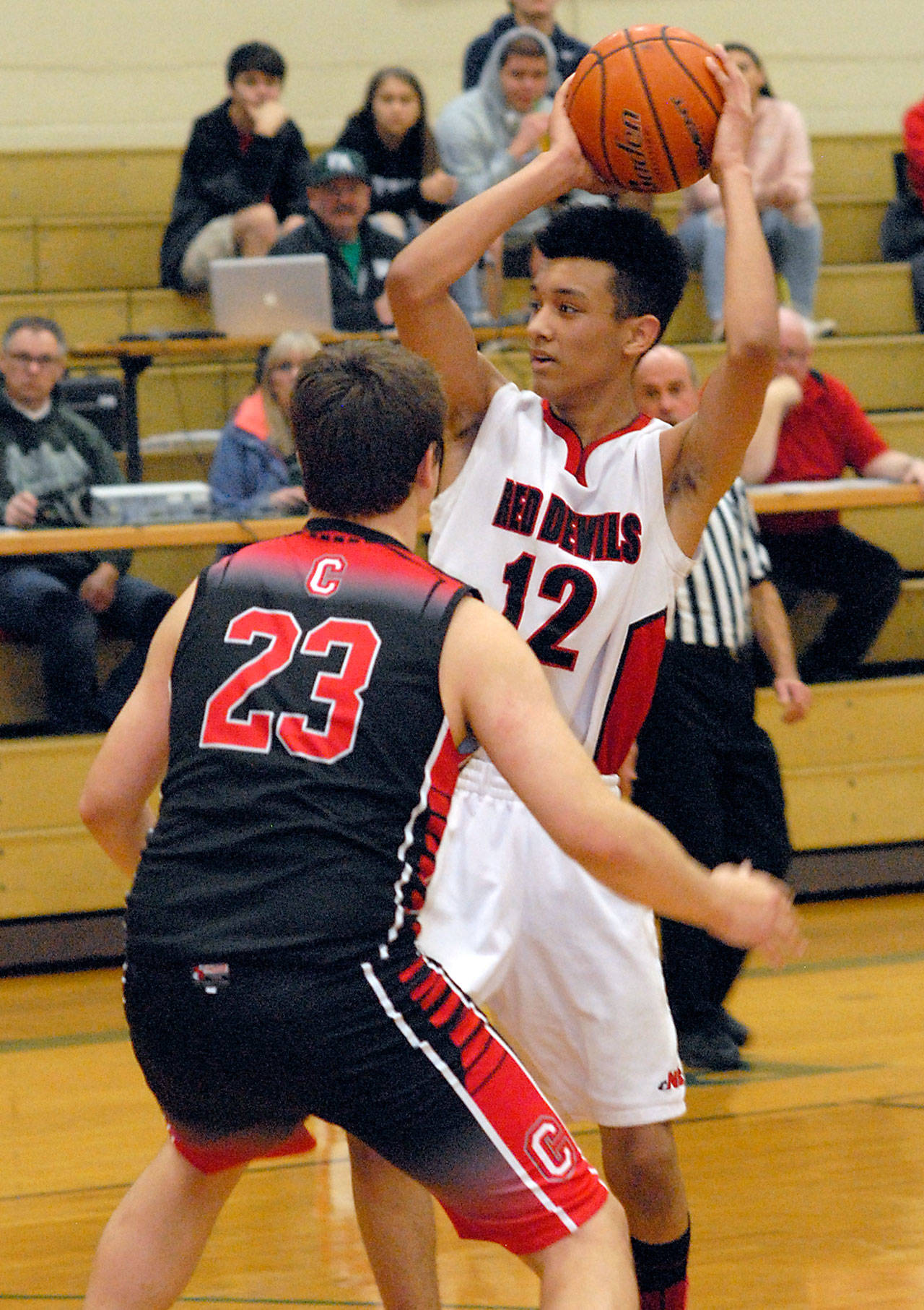 Keith Thorpe/Peninsula Daily News Neah Bay’s Sean Bitegeko, right, looks for a way around the defense of Crosspoint’s Derrin Doty Jr., on Friday during first-round play in the Port Angeles Holiday Basketball Tournament at Port Angeles High School.