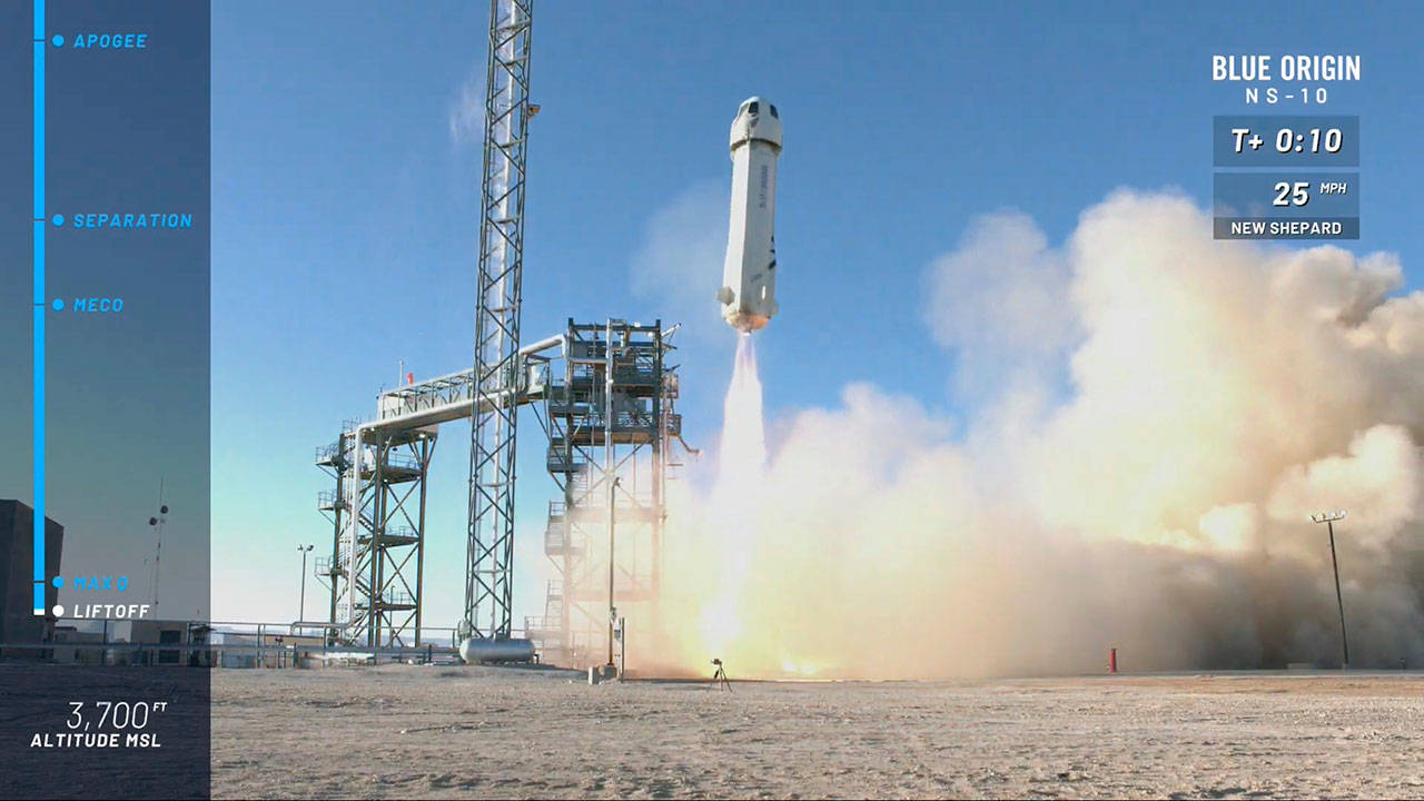 In this image from video made available by Blue Origin, the New Shepard capsule and booster lifts off from the company’s site in west Texas. Jeff Bezos’ rocket company launched NASA experiments into space on the brief test flight. (Blue Origin via AP)