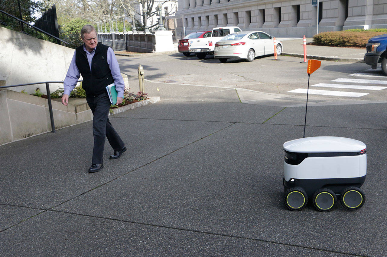 State Rep. Steve Tharinger, D- 24th District, walks by a delivery device during a demonstration outside the state Capitol in Olympia on Monday. (Rachel La Corte/The Associated Press)