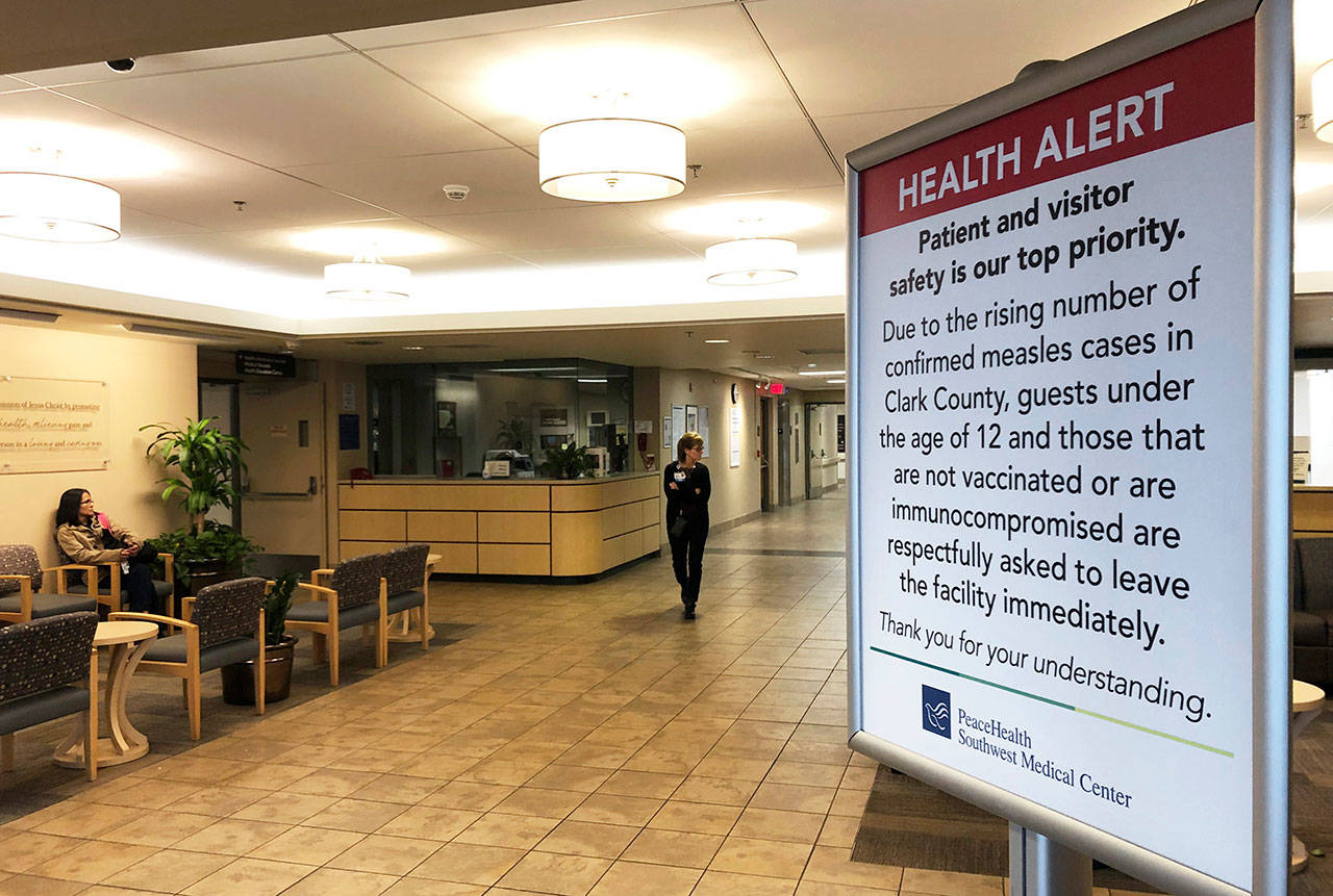 A sign prohibiting all children under 12 and unvaccinated adults stands at the entrance to PeaceHealth Southwest Medical Center in Vancouver, Wash., on Jan. 25. (Gillian Flaccus/The Associated Press)