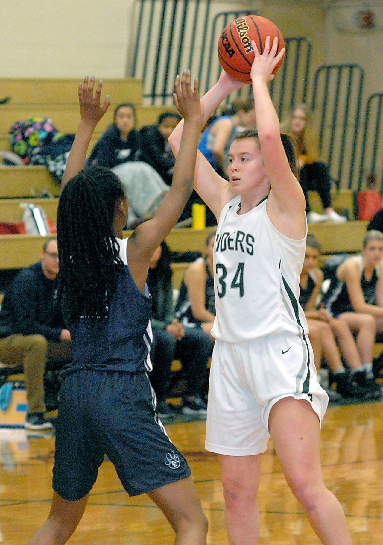 Keith Thorpe/Peninsula Daily News Port Angeles’ Jaida Wood, right, looks over the defense of Cascade Christian’s Anniah Smith in December.