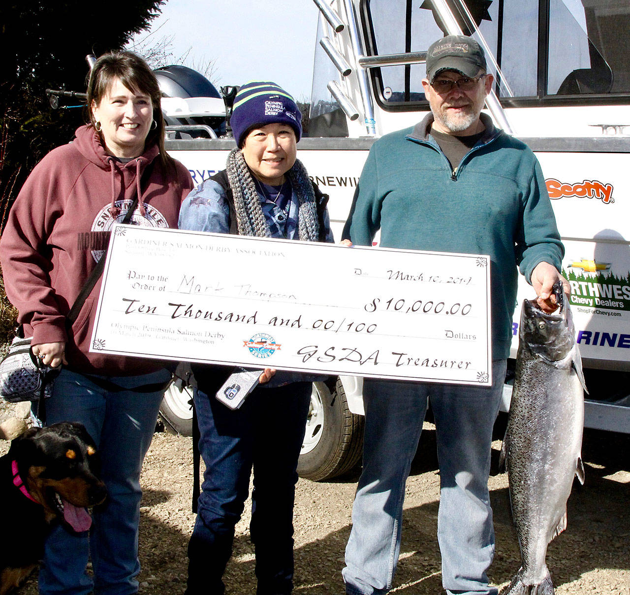 Dave Logan/for Peninsula Daily News Mark Thompson of Clinton, right, poses with his 19.35-pound winning catch from the Olympic Peninsula Salmon Derby, with his wife Kristi Thompson, left and Gardiner Salmon Derby President Kathy Watrous.