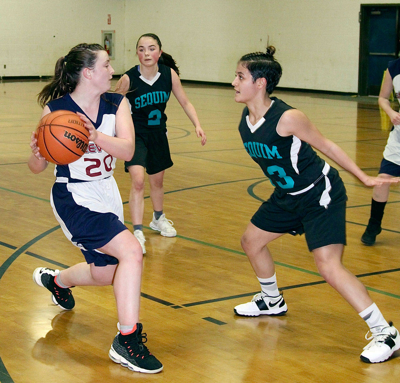 Dave Logan/for Peninsula Daily News Kaylen Cockrill, left, of Stevens Middle School looks for help while defended by Sequim’s Olivia Duran during Sequim’s 51-24 win over their Port Angeles rivals. Sequim is now 6-0 on the season, while Stevens is 3-3.