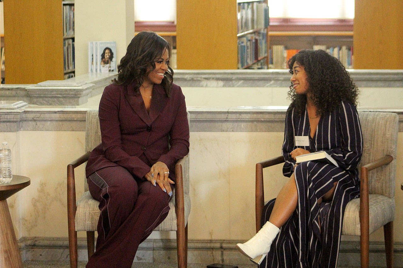 Former first lady Michelle Obama, left, chats with Lestraundra Alfred, founder of Balanced Black Girl podcast at a private book club event at the Tacoma Public Library on Sunday. (Olivia Sullivan/Federal Way Mirror)