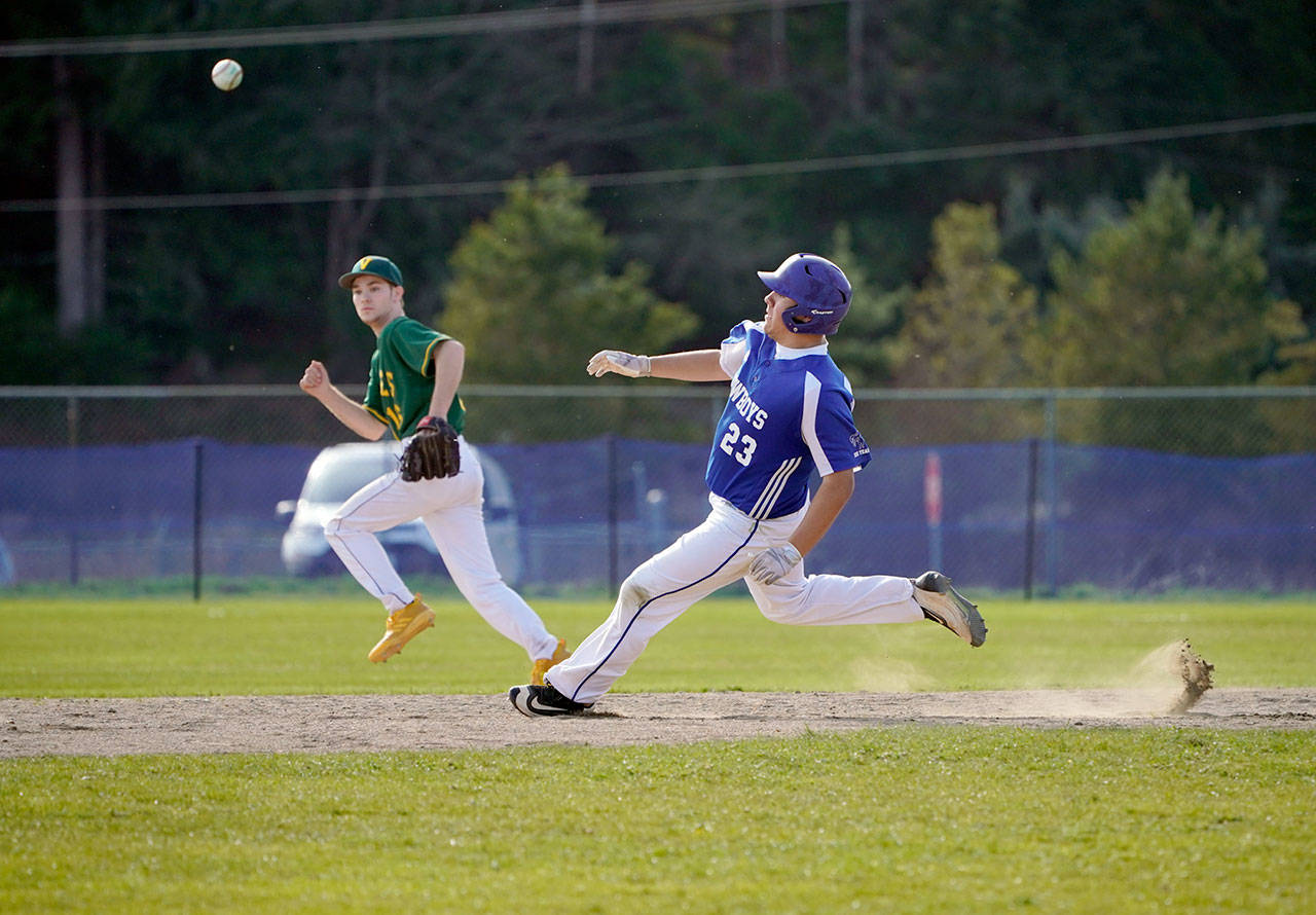 Cowboy Aaron Serrato out-races the ball as he turns the corner at first and charges to second base during a Friday afternoon game against the Vashon Pirates in Chimacum. (Steve Mullensky/for Peninsula Daily News)