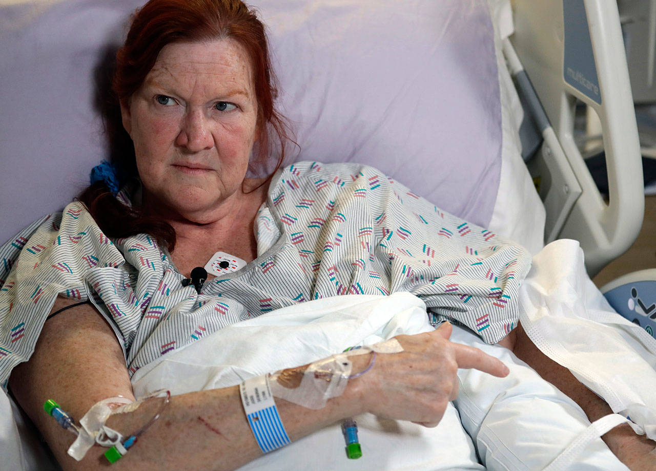 Deborah Judd, 56, sits in her hospital bed Thursday at Harborview Medical Center and talks about the injuries she suffered in a shooting a day earlier in Seattle. (Elaine Thompson/The Associated Press)