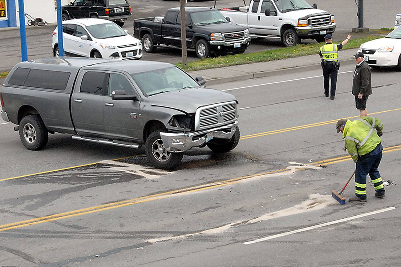 Crews clean up the scene of a two-vehicle collision on U.S. Highway 101 east of Golf Course Road in Port Angeles on Thursday. The wreck snarled traffic around the scene until the street could be cleared. (Keith Thorpe/Peninsula Daily News)