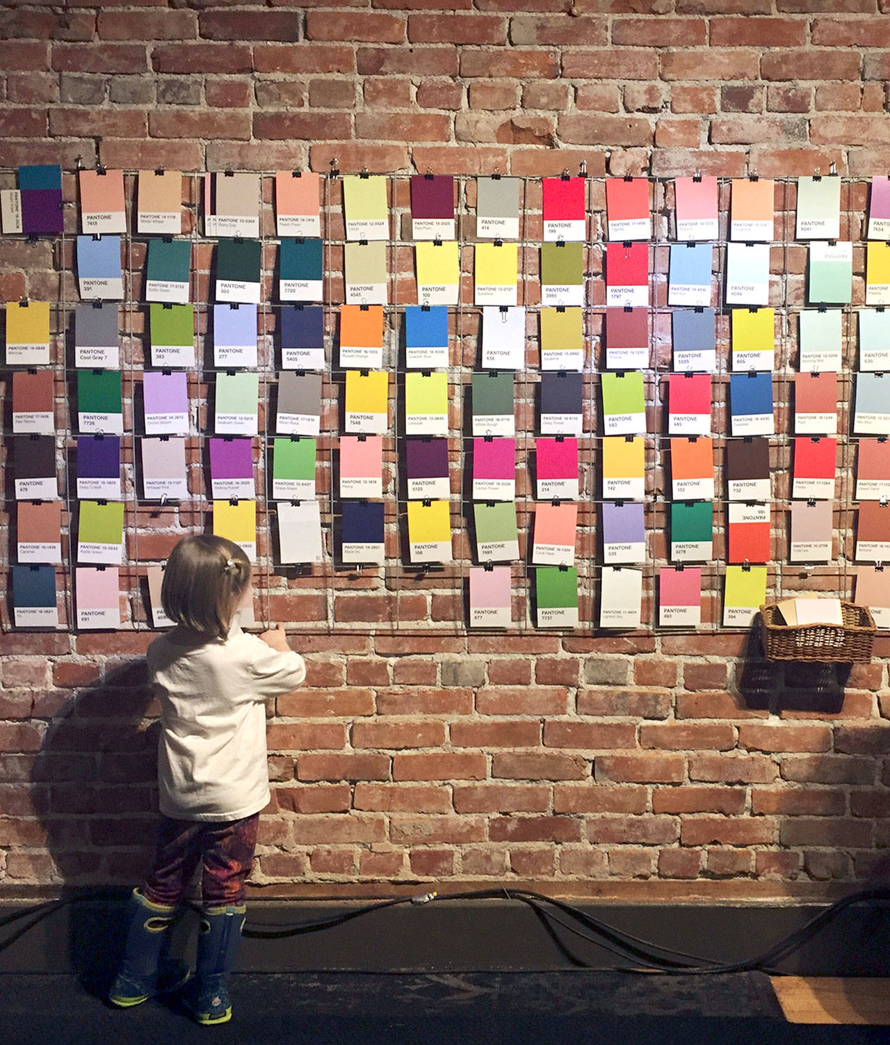 Adele Caemmerer’s “Pantone Wall,” one of the pieces in the “pARTicipation” shown at the Port Angeles Fine Arts Center, invites passers-by to select color cards from a big stack and add them to the wall grid wherever they like. Over time, the grid will fill up with colors, turning into a multi-hued, abstract creation.