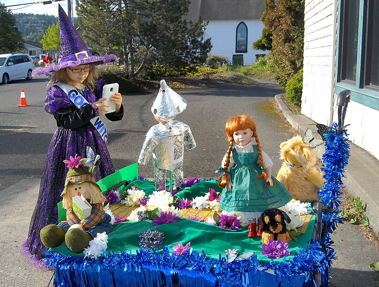 Six-year-old Leya Semsintaffar of Sequim, dressed as a good witch from the “Wizard of Oz,” takes a cellphone photo of her float, themed around characters of the movie at the start of Saturday’s Irrigation Festival Kiddie Parade through downtown Sequim. The parade was a featured event of the two-week festival’s kickoff weekend. (Keith Thorpe/Peninsula Daily News)