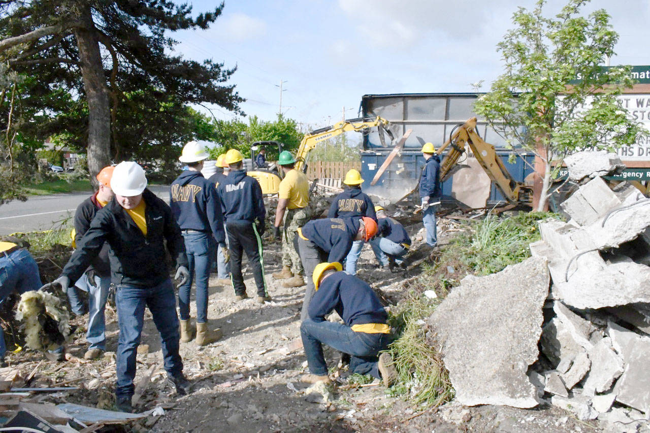 Volunteers from Naval Magazine Indian Island help clean up debris after the abandoned visitor center on Sims Way was torn down to make room for Port Townsend’s newest park, Gateway Plaza. (Jeannie McMacken/Peninsula Daily News)