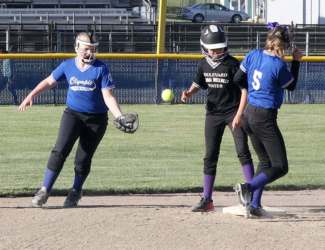 <strong>Dave Logan</strong>/for Peninsula Daily News                                Boulevard Wellness’ Malena Marquez stands up safely after stealing second base while Olympic Labor Council’s Violet Mills (5) and her teammate Evie Seeyle attempt to field the ball.